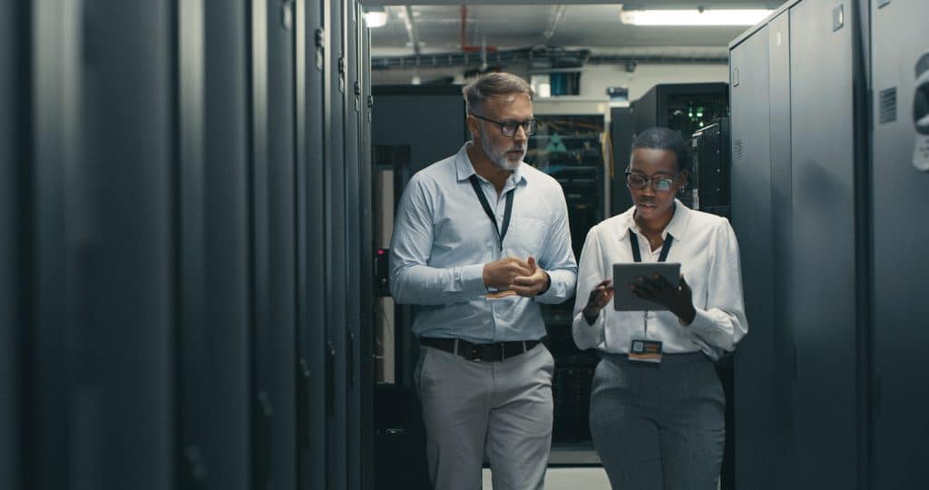 Man and woman using a digital tablet in a data centre