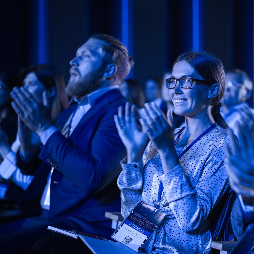 Young female delegate applauding at a science conference