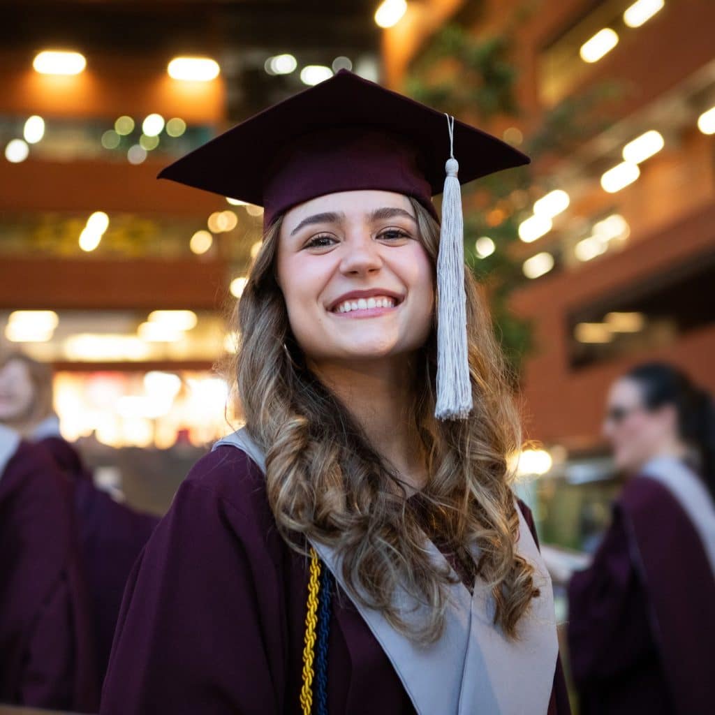 Young female graduates smiling during graduation ceremony