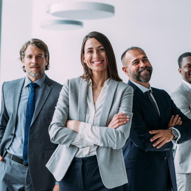 Confident businesswoman smiling in front of her team
