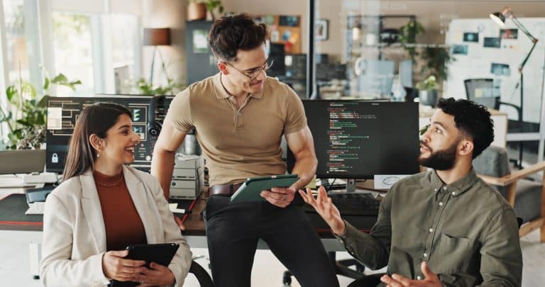 Smiling male entrepreneur with colleagues in office